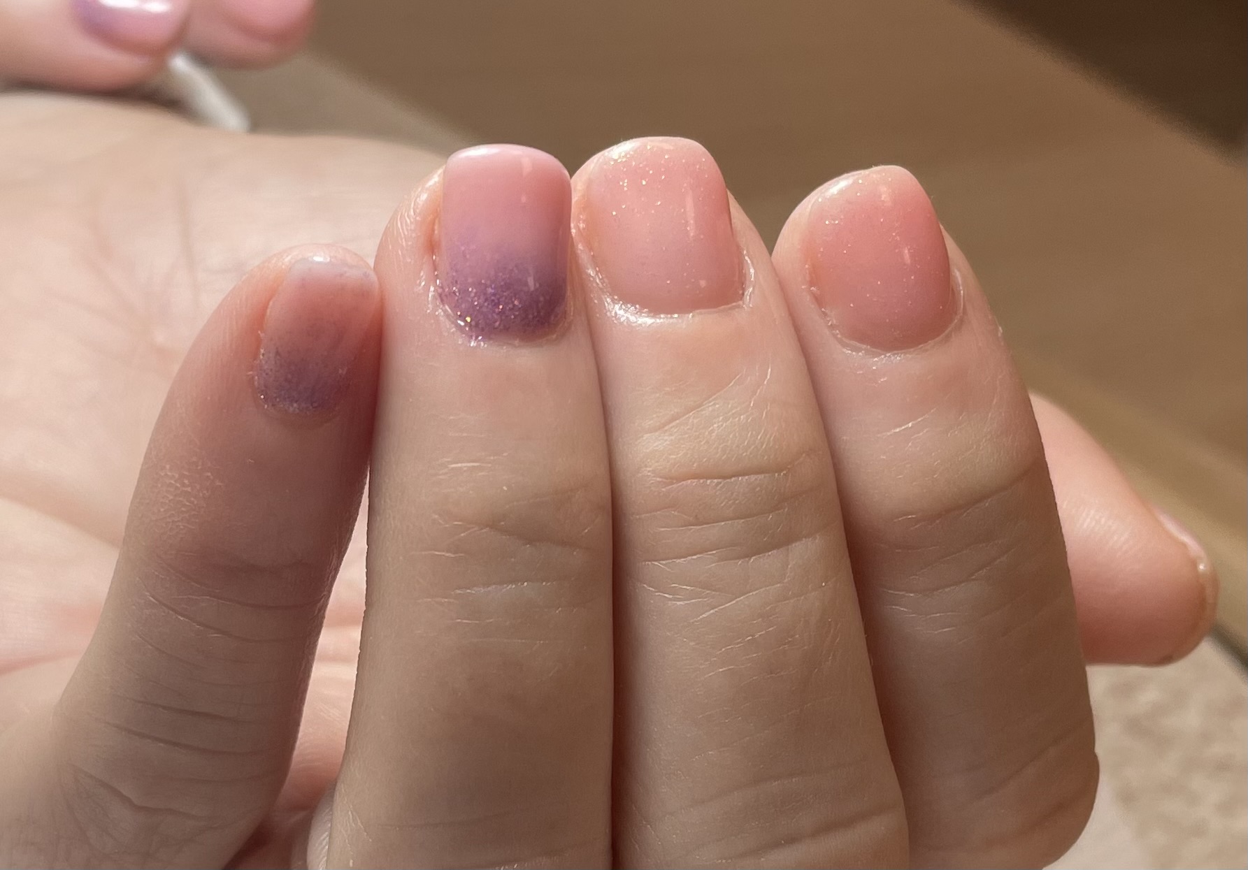 Manicura en tonos nude y malva con detalle glitter